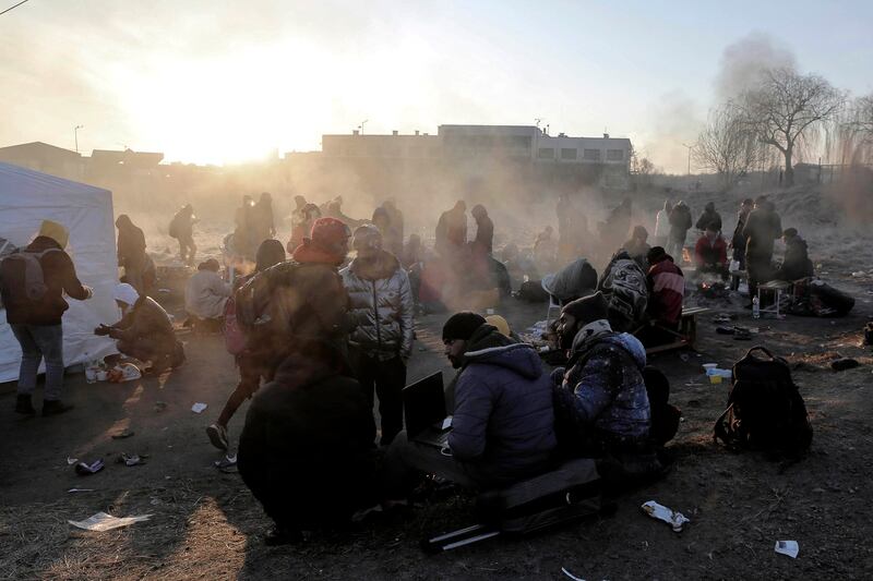 Refugees try to stay warm after fleeing the Russian invasion of Ukraine, at the Medyka border crossing in Poland, Tuesday, March 1, 2022. Credit: AP