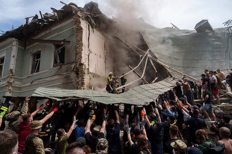 Emergency services workers clear debris at a children's hospital hit by Russian missiles, in Kyiv, Ukraine, July 8, 2024. (Evgeniy Maloletka/AP)