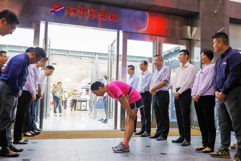 Employees line up to show gratitude to customers at the entrance of Pacific Department Store on the same day they officially close, Aug. 31, 2023 in Shanghai, China. (Yin Liqin/China News Service/VCG via Getty Images)