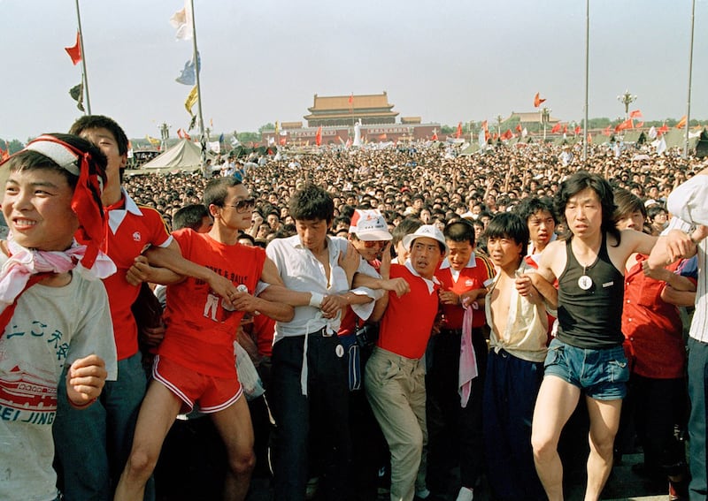 1989年6月2日，学生组织者手挽手聚集在天安门广场的汹涌人群。（ AP Photo/Mark Avery）