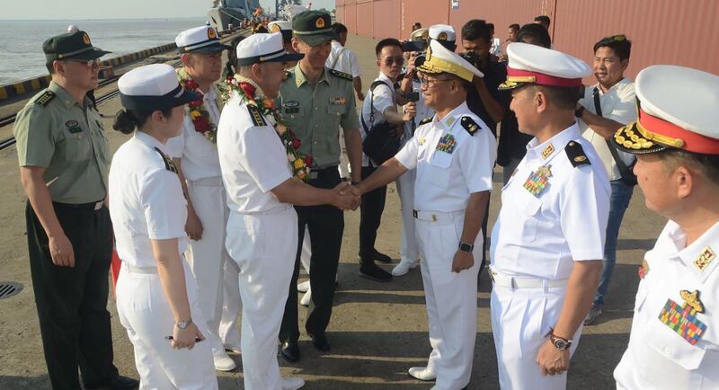 Senior Myanmar naval officers [right] welcome members of the Chinese navy upon their arrival at Thilawa Port in Yangon, Myanmar, Monday, Nov. 27, 2023. (AFP/Myanmar's Military Information Team)