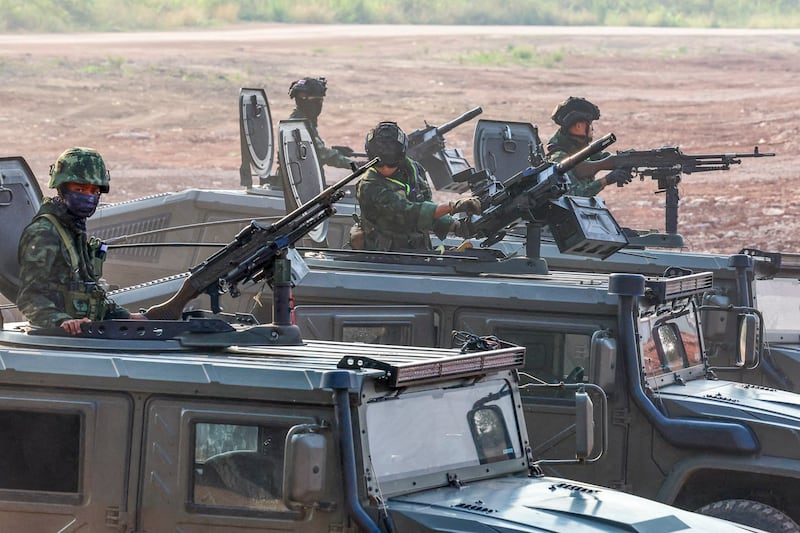 Military personnel stand guard as hundreds of refugees crossed over the Moei River frontier between Myanmar and Thailand in Mae Sot, Tak province, Thailand, April 13, 2024.(Athit Perawongmetha/Reuters)