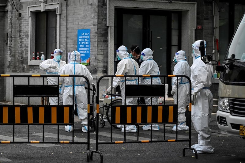 Workers wearing personal protective equipment (PPE) are seen at an entrance to an alley in a neighborhood under lockdown due to Covid-19 in Beijing, May 24, 2022. Credit: AFP